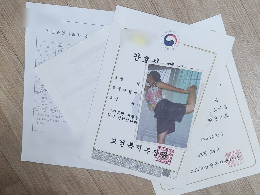 A stack of real certificates and licenses — nursing, tutoring, youth counseling — with an old photo of the author dancing on top: ten dreams in paper form.